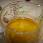 Olive oil, lemon juice, sesame oil, and minced garlic in a measuring cup.
